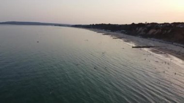 İnsanlar İngiltere 'nin Bournemouth kumlu plajında, güzel Britanya Deniz Manzarası ve Büyük Britanya' nın Temiz Okyanusu 'nda eğleniyor ve dinleniyorlar.