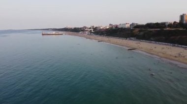 People are Enjoying and relaxing at Bournemouth Beach of England UK, The Footage taken at Bournemouth Beach on the Hottest Summer Day. The Sea view was full of people, most of them was swimming in the ocean water, 