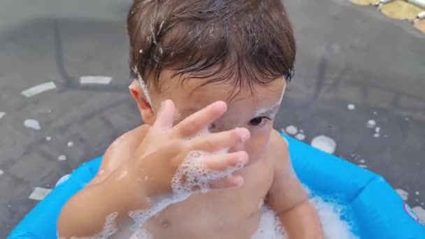 一年大的亚洲男婴在水桶里享受着快乐 — 图库视频影像