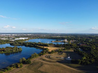 High Angle Footage of Willen Lake, Water Sports and Public Park of England. which is located at Milton Keynes, England.+ People are Enjoying at Lake on a Hot Sunny Day of Summer. Video Clip Captured on 21-Aug-2022. Beautiful Aerial Drone's Footage.