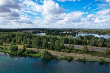 High Angle Footage of Willen Lake, Water Sports and Public Park of England. which is located at Milton Keynes, England.+ People are Enjoying at Lake on a Hot Sunny Day of Summer. Video Clip Captured on 21-Aug-2022. Beautiful Aerial Drone's Footage.
