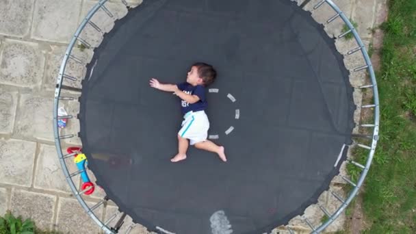 Baby Boy Poseert Onder Camera Van Drone Een Trampoline Tuin — Stockvideo