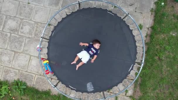 Baby Boy Poseert Onder Camera Van Drone Een Trampoline Tuin — Stockvideo