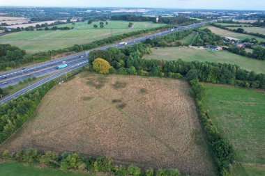 High Angle View of British Motorways at M1 and M25 Interchange. Highways are Passing from Beautiful Landscape with agricultural farms. Aerial View was captured with drone's camera on 7th Sep 2022. 