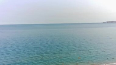 BİRLİK KINGDOM, BOURNEMOUTH BEACH - 18 Temmuz 2022: insanlar yaz tatillerinde eğleniyorlar. Yüksek Açı Drone Kamera Görünümü