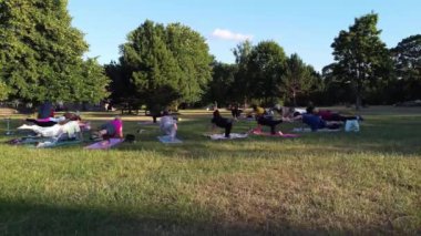 ENGLAND, LUTON TOWN - 04th April 2022: Genç İngiliz Kadınlardan oluşan bir grup, Wardown Halk Parkı Yüksek Açılı Görüntü Parkı 'nda egzersiz yapıyor. Luton Kasabası 'nda Parlak Güneşli Gün