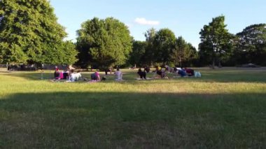 ENGLAND, LUTON TOWN - 04th April 2022: Genç İngiliz Kadınlardan oluşan bir grup, Wardown Halk Parkı Yüksek Açılı Görüntü Parkı 'nda egzersiz yapıyor. Luton Kasabası 'nda Parlak Güneşli Gün