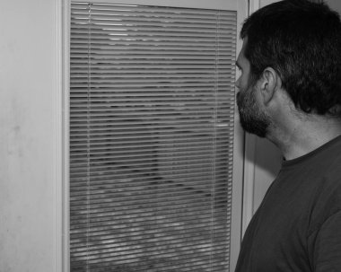 Seasonal Affective Disorder - SAD - Depressed man looking aimlessly out the window - Mental Health