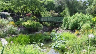 Green bridge in the middle of a flower garden in Overland Park Kansas on a hot sunny Summer day.