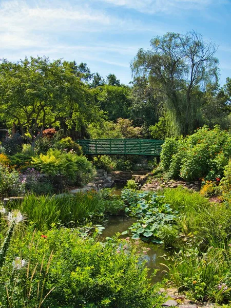 Green bridge in the middle of a flower garden in Overland Park Kansas on a hot sunny Summer day.