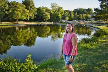 Brunette standing by the reflective waters of Sar Ko Par Park in Lenexa Kansas