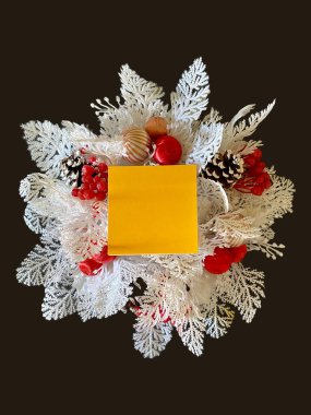 Merkezinde turuncu yapışkan bir notla siyah bir arkaplan üzerindeki beyaz çelengin bu yakın plan resmine metin ekle