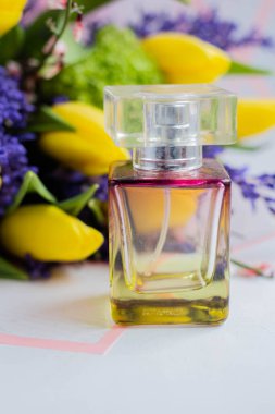 Bahar çiçekli bir şişe kadın parfümü. Laleler. Hediye. Buketle birlikte 