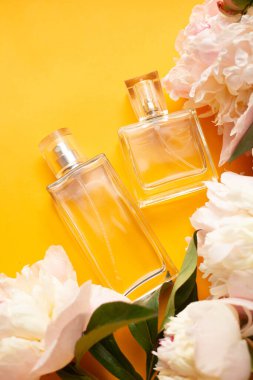 Turuncu masasında şakayık olan parfüm şişeleri