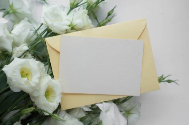 Östomalı maket kartı. Ortam ve ayrıntıları içeren davet kartı beyaz arkaplanda kartpostal ve çiçeklerle düzenlenir.