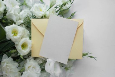 Östomalı maket kartı. Ortam ve ayrıntıları içeren davet kartı beyaz arkaplanda kartpostal ve çiçeklerle düzenlenir.