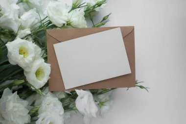 Östomalı maket kartı. Ortam ve ayrıntıları içeren davet kartı beyaz arkaplanda kartpostal ve çiçeklerle düzenlenir.