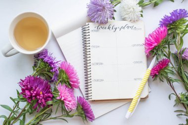 Asterlar, çay ve sonbahar çiçekleriyle haftalık planlamacı..