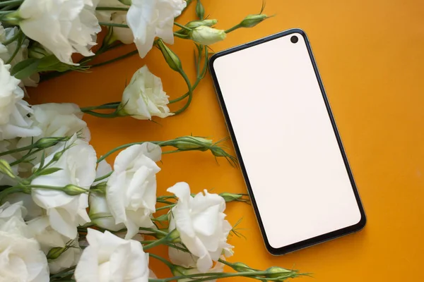 Telefon maketi. Eustoma çiçekleri eşliğinde. minimalist 