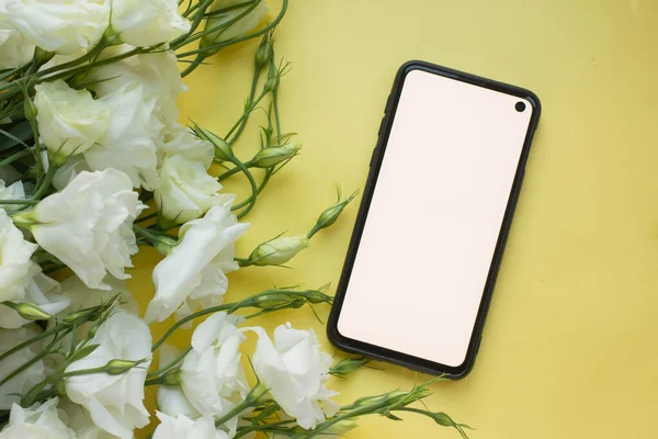 Telefon maketi. Eustoma çiçekleri eşliğinde. minimalist 
