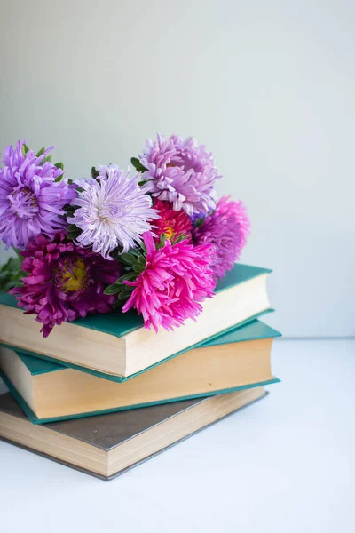 Books and flowers. asters bouquet background