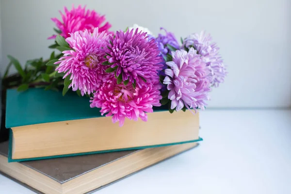 Books and flowers. asters bouquet background