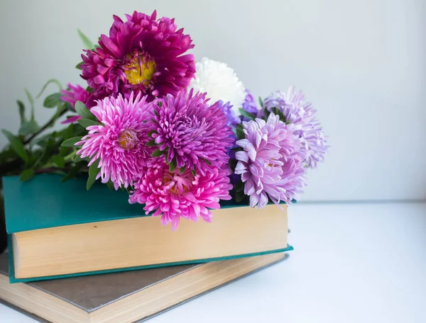 Books and flowers. asters bouquet background