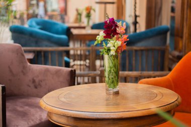 Çiçekleri ve sandalyeleri olan rahat bir kafe.