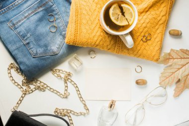 card mockup with yellow sweater and blue jeans, golden details, tea with lemon and fall leaves