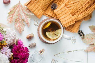 cup of tea with lemon. flowers and yelow sweater