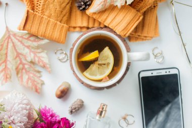cup of tea with lemon. flowers and yelow sweater