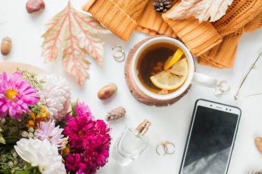 cup of tea with lemon. flowers and yelow sweater