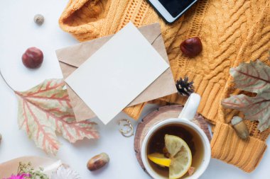 fall mockup card with autumn leaves invitation card with environment and details Mockup with postcard and sweater with wood elemets on white background.