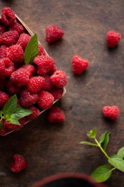 fresh raspberry in basket on dark wooden background