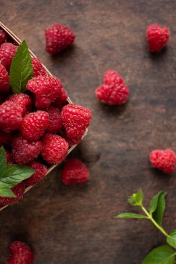 fresh raspberry in basket on dark wooden background