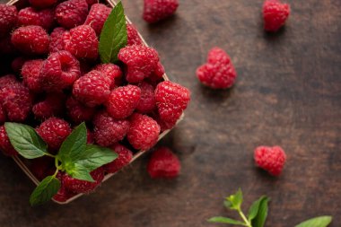 fresh raspberry in basket on dark wooden background