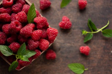 fresh raspberry in basket on dark wooden background
