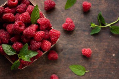 fresh raspberry in basket on dark wooden background