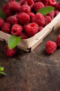 fresh raspberry in basket on dark wooden background
