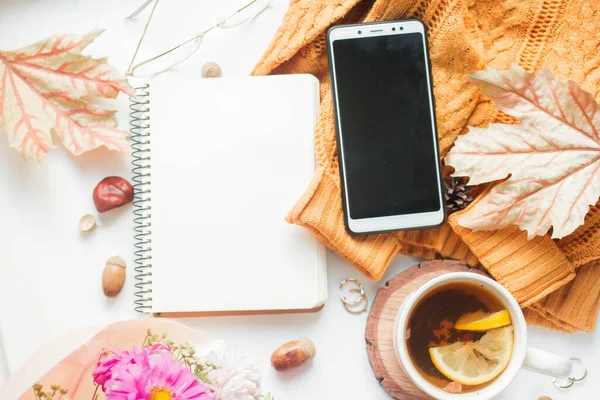 fall mockup notebook with phone and autumn leaves and details Mockup with postcard and flowers and ribbon on white background.
