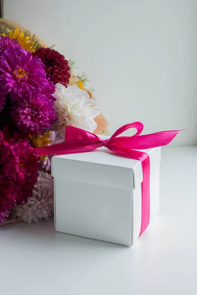 gift box with colorful flowers. asters. autumn bouquet on table
