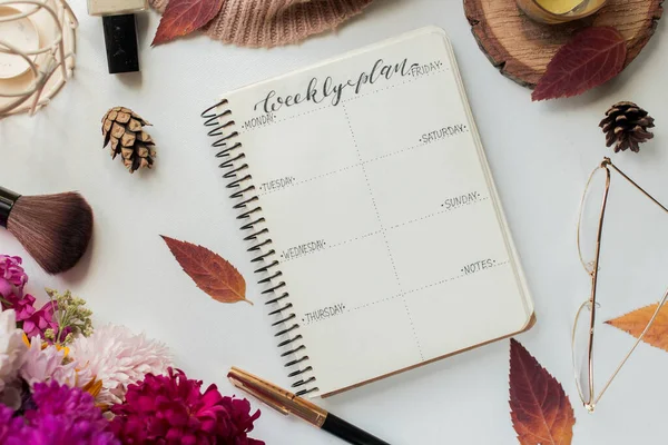 weekly planner with asters and candle. autumn leaves and flowers