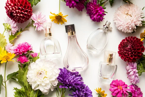 perfume bottles with colorful flowers. asters. autumn bouquet on table