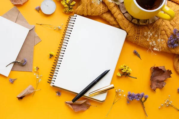 notebook with dry flowers and leaves. planner with tea and pen