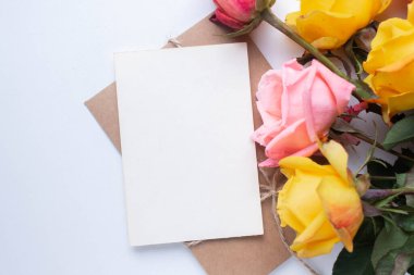 mockup card with roses. invitation card with environment and details Mockup with postcard and flowers on white background.