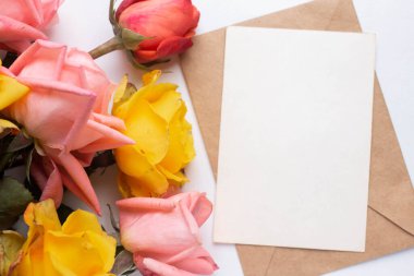 mockup card with roses. invitation card with environment and details Mockup with postcard and flowers on white background.