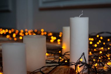 autumn background with candles on a plaid and garland. fall cozy mood