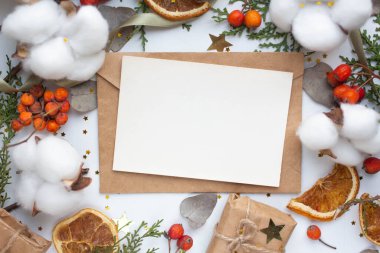 Hediye kutusu, okaliptüs yaprakları, pamuk çiçekleri ve kırmızı böğürtlenli kart modeli. Düz yerde, üst tarafta. zanaat minimalist hediyeler