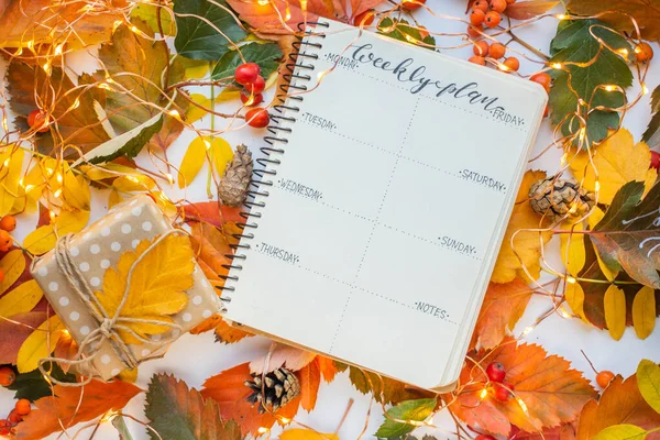 weekly planner with autumn leaves, gift box and garland