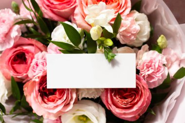 Bir buket çiçek ve gönderenden bir kart. Bilinmeyen bir hayran. Güller, karanfiller, lisianthus. Kart modeli